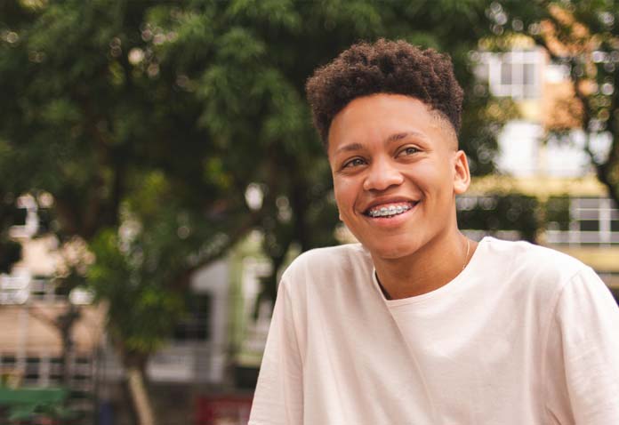 Boy in a white t-shirt with braces smiling