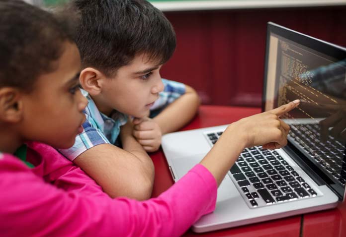 Two students collaborating while using a computer