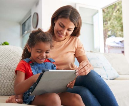 Mother helping child using tablet